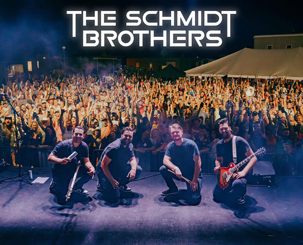 The Schmidt Brothers smiling in front of a cheering crowd