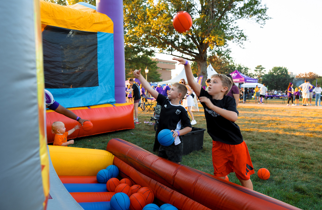 Two boys playing an inflatable basketball carnival game